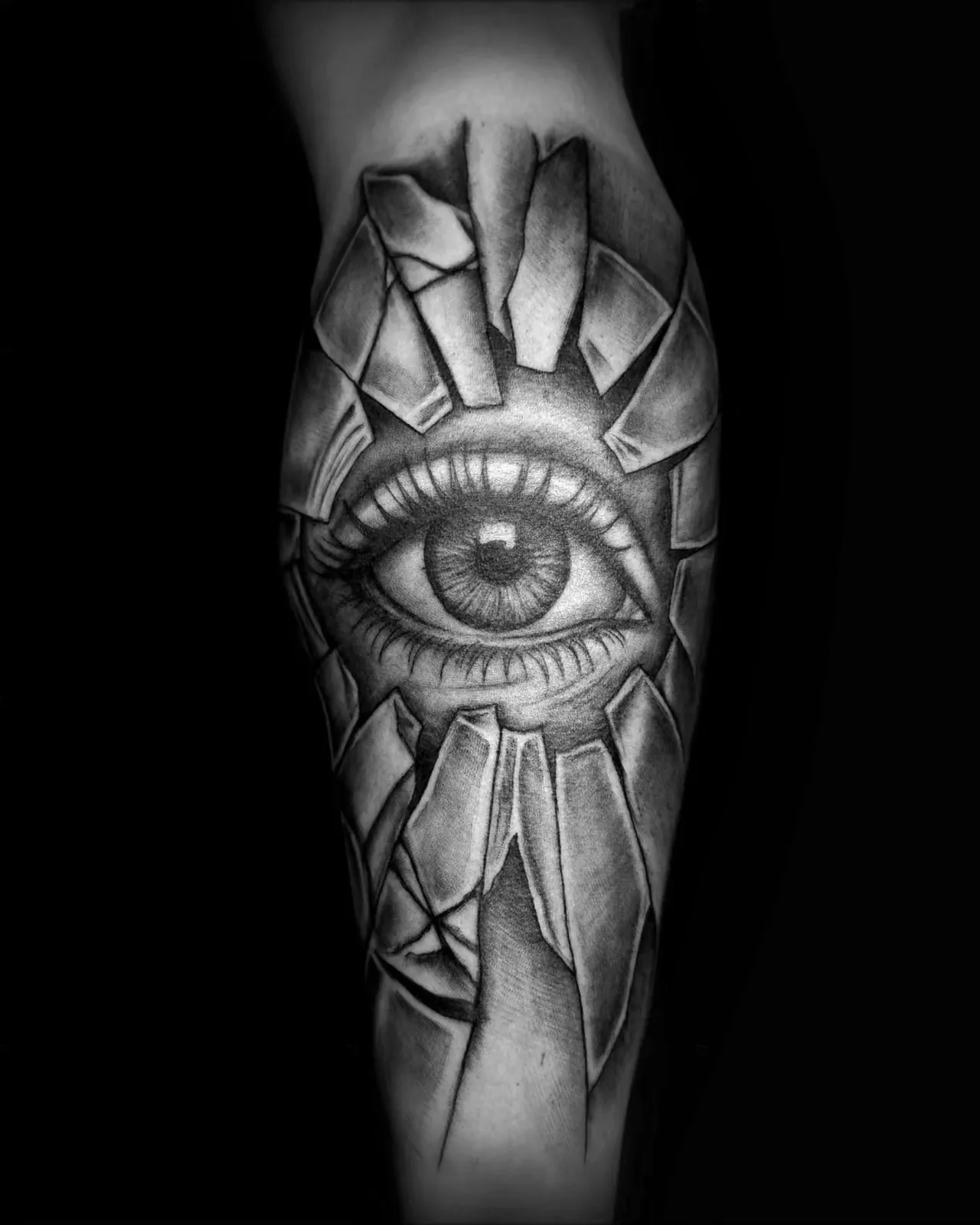 Realistyczny tatuaż oka w pękniętym szkle na przedramieniu, wykonany w PM Tattoo w Legnicy