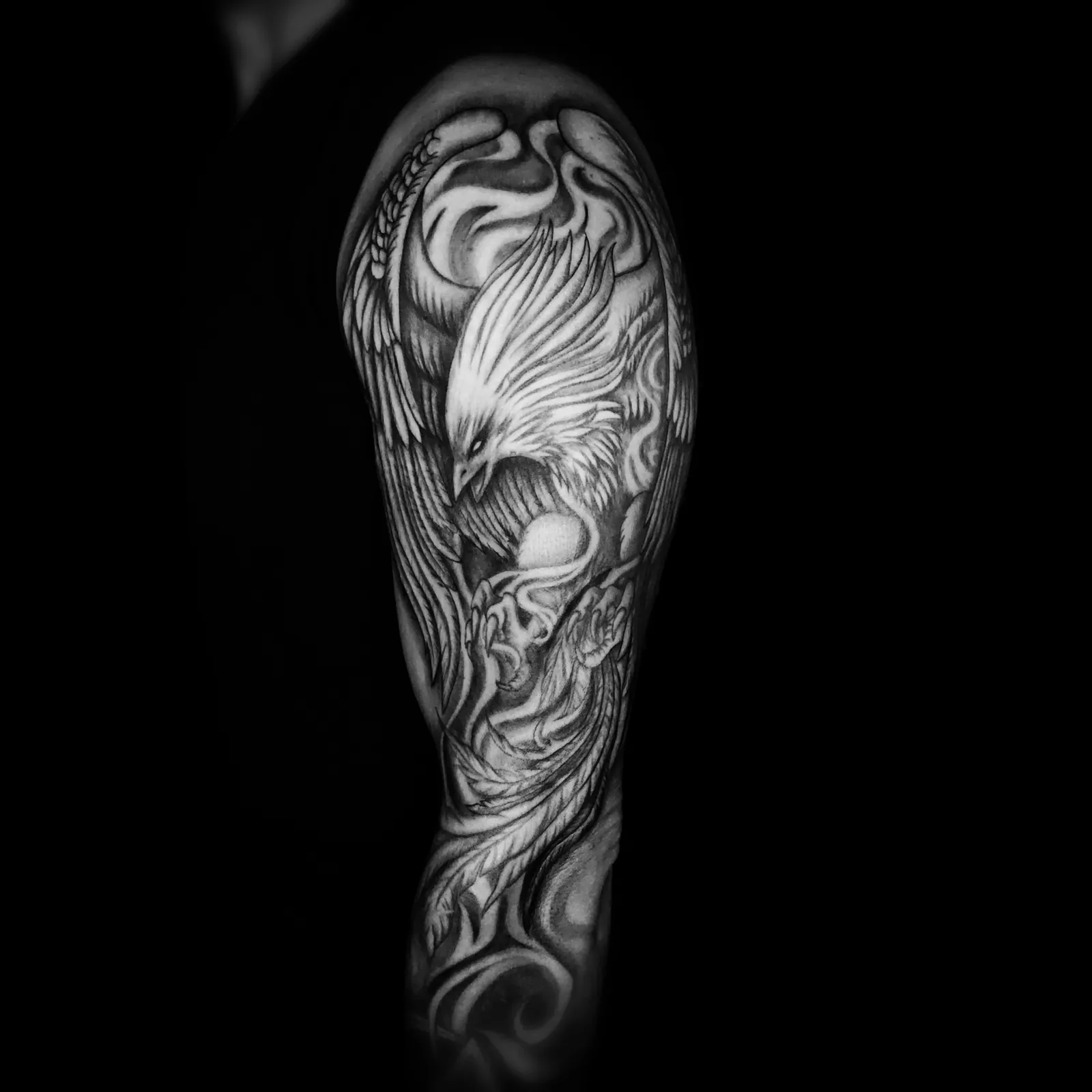Graficzny tatuaż feniksa z płomieniami na całym ramieniu, wykonany w PM Tattoo w Legnicy