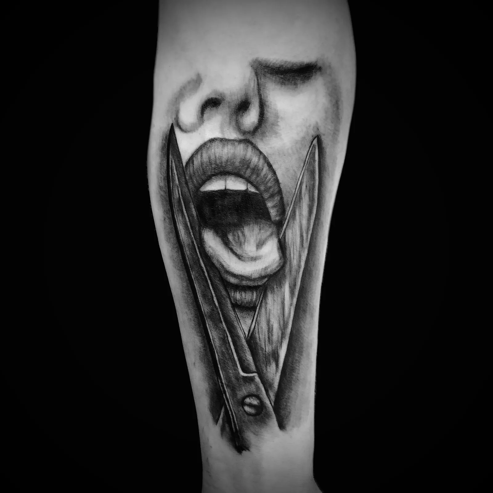 Realistyczny tatuaż otwartych ust z nożyczkami na przedramieniu, wykonany w PM Tattoo w Legnicy