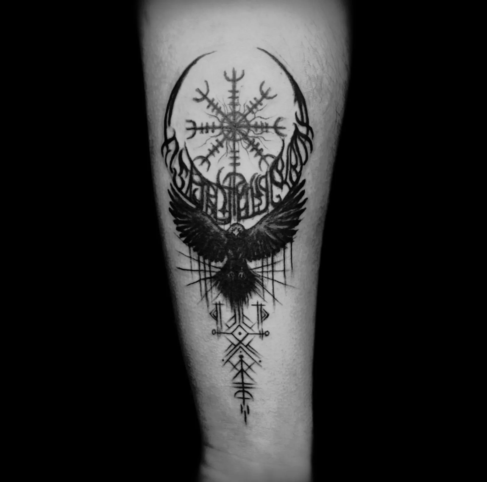 Blackwork tatuaż kruka z runicznym kompasem na przedramieniu, wykonany w PM Tattoo w Legnicy