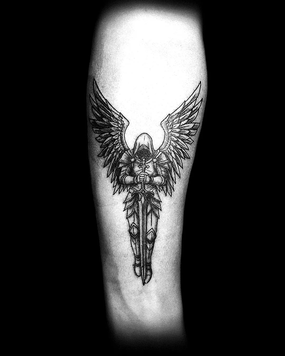 Graficzny tatuaż anioła z mieczem na przedramieniu, wykonany w PM Tattoo w Legnicy