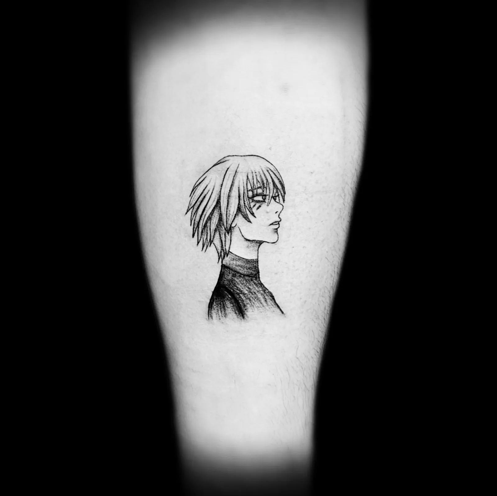 Tatuaż fine line portretu postaci anime na ramieniu, wykonany w PM Tattoo w Legnicy