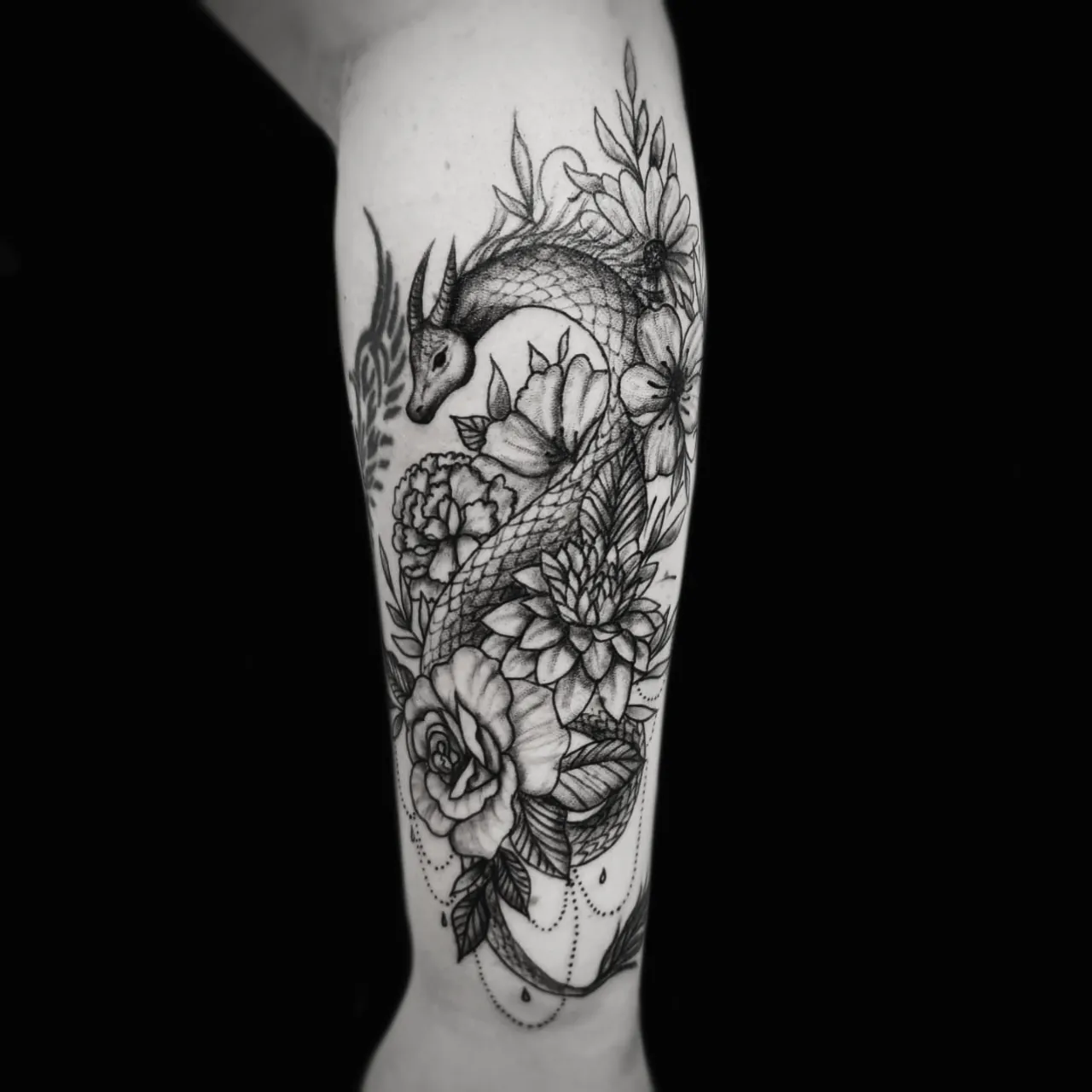 Graficzny tatuaż kompozycji kwiatów z rybą koi na ramieniu, wykonany w PM Tattoo w Legnicy