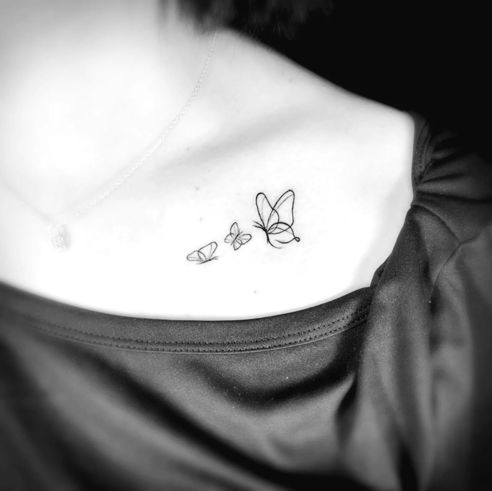 Delikatny tatuaż trzech motyli na obojczyku, wykonany w PM Tattoo w Legnicy