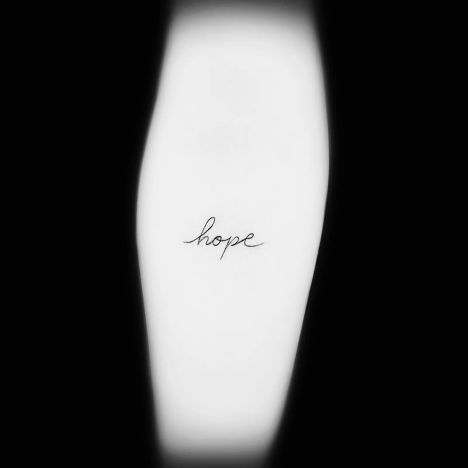 Minimalistyczny tatuaż napisu hope cienką kreską, wykonany w PM Tattoo w Legnicy
