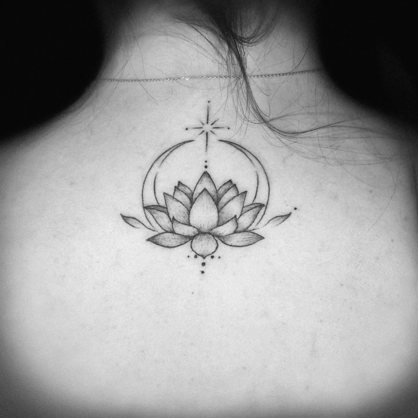 Delikatny tatuaż kwiatu lotosu z półksiężycem na karku, wykonany w PM Tattoo w Legnicy