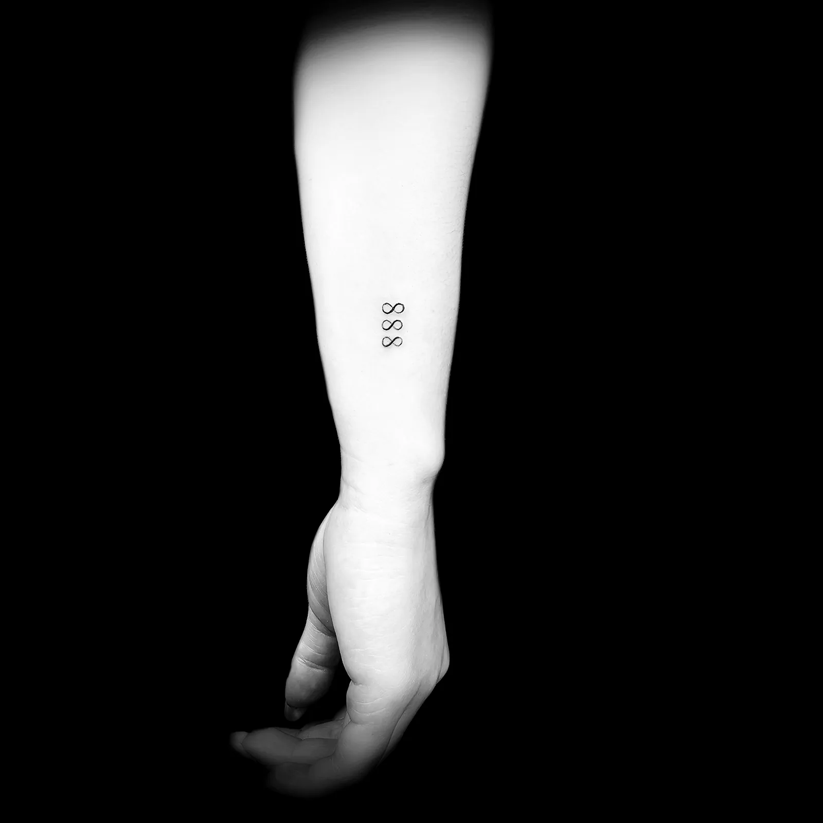 Minimalistyczny tatuaż drobnych cyfr na przedramieniu, wykonany w PM Tattoo w Legnicy
