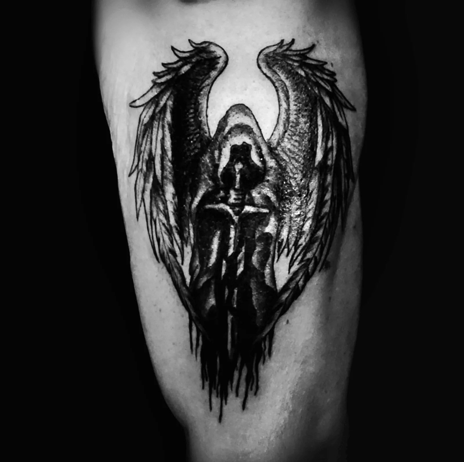 Blackwork tatuaż anioła z rozpostartymi skrzydłami na ramieniu, wykonany w PM Tattoo w Legnicy