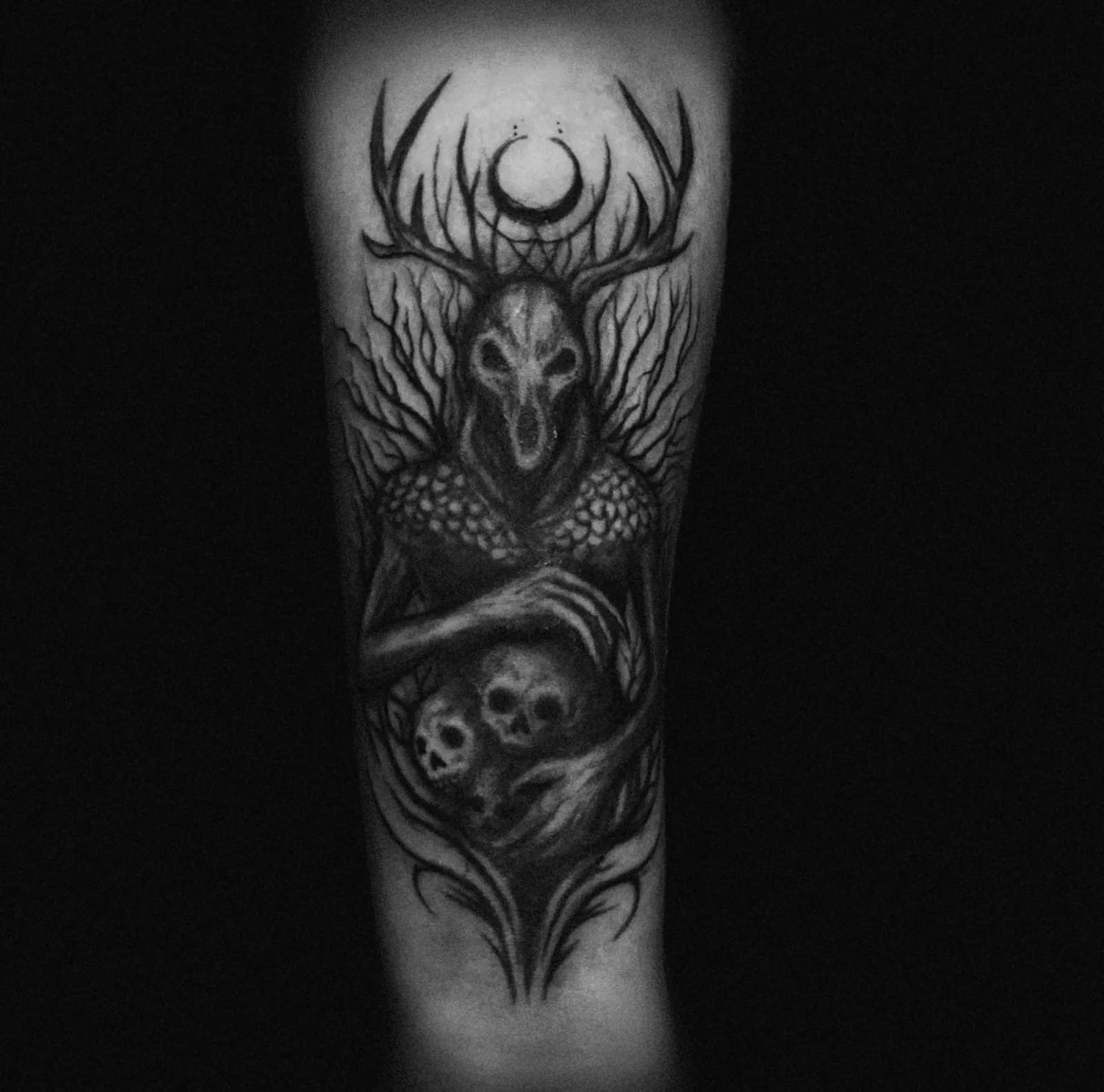 Realistyczny tatuaż czaszki jelenia z czaszkami i lasem na przedramieniu, wykonany w PM Tattoo w Legnicy